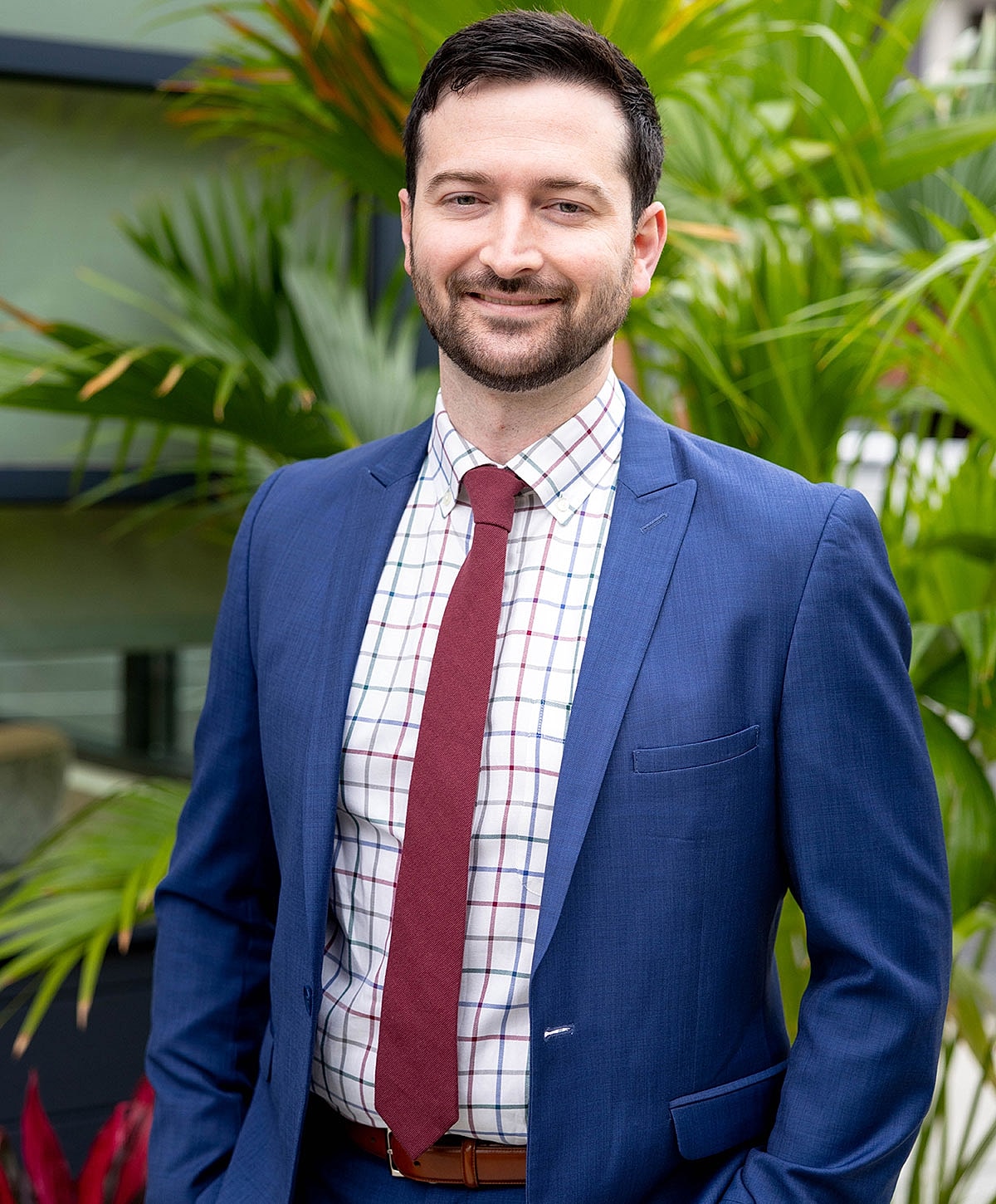 Man in suit with plants background.